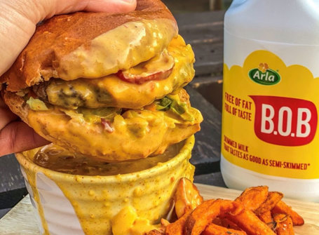 A burger being dipped into burger dipping sauce