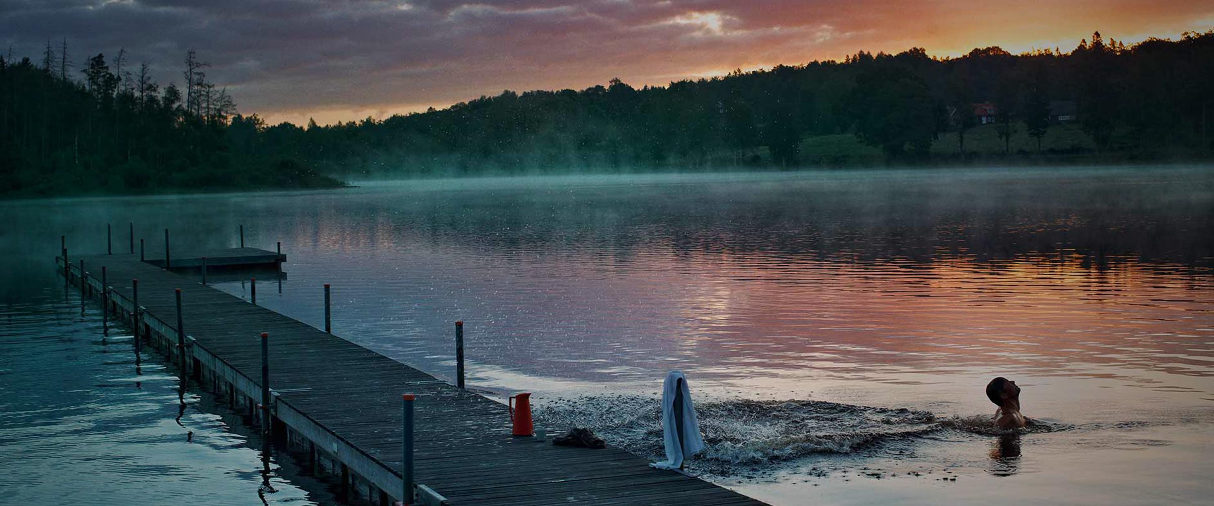 A swimmer in a forest-side lake