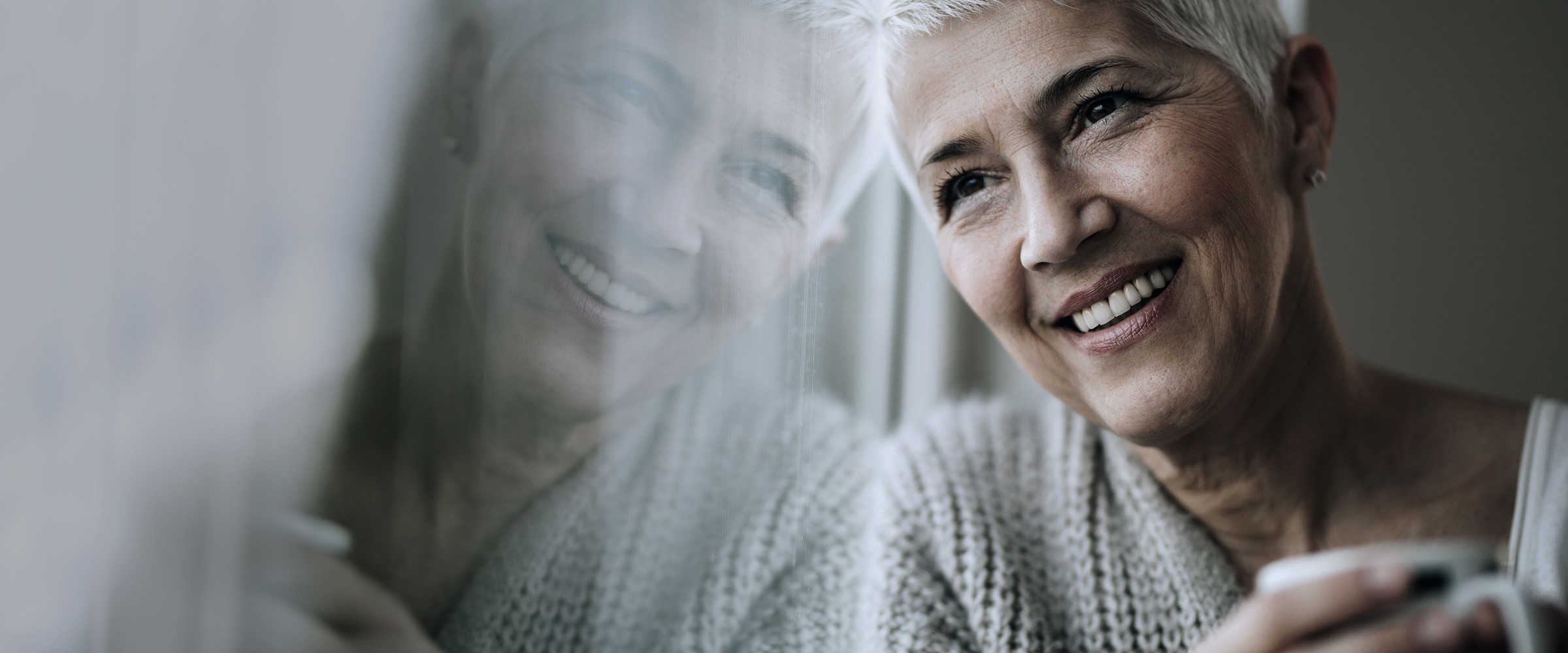 An older woman staring out of a window